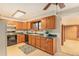 Well-lit kitchen featuring wood cabinets, black appliances, and ample counter space at 6047 Vivian Ct, Arvada, CO 80004