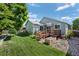 Landscaped backyard with a wood deck, lush green grass, rock accents, and mature tree, creating a tranquil outdoor space at 8761 Cloverleaf Cir, Parker, CO 80134