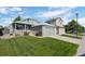 Charming home featuring a well-manicured front yard, colorful flowers, and an attached two-car garage at 8761 Cloverleaf Cir, Parker, CO 80134