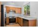 Bright kitchen with stainless steel appliances, wood cabinets, and a window overlooking the yard at 8761 Cloverleaf Cir, Parker, CO 80134