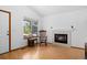 Bright living room with hardwood floors, a cozy fireplace, and a large window providing natural light at 8761 Cloverleaf Cir, Parker, CO 80134
