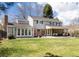 Expansive backyard with a well-maintained lawn, covered patio, and multiple access doors to the house at 6964 S Olive Way, Centennial, CO 80112