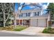 Classic two-story home with brick accents, a red front door, attached two-car garage, and well-kept landscaping at 6964 S Olive Way, Centennial, CO 80112