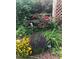 Lush garden with roses climbing on a trellis, surrounded by colorful perennials, and featuring landscape lighting at 6964 S Olive Way, Centennial, CO 80112
