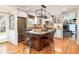 Spacious kitchen featuring a central island with seating, stainless steel appliances, and modern lighting fixtures at 6964 S Olive Way, Centennial, CO 80112