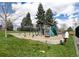 Community playground featuring swings, climbing structures, and slides in a well-maintained grassy area at 6964 S Olive Way, Centennial, CO 80112