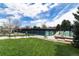 Well-maintained community tennis courts with viewing benches surrounded by lush greenery and open blue sky at 6964 S Olive Way, Centennial, CO 80112