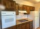 Functional kitchen with wooden cabinets, tile backsplash and white appliances at 598 Toledo St, Aurora, CO 80011