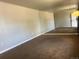 Spacious living room featuring neutral walls, brown carpet, and light fixtures at 598 Toledo St, Aurora, CO 80011