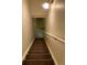Carpeted stairwell with a handrail, illuminated by an overhead light fixture at 598 Toledo St, Aurora, CO 80011