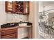 A cozy wet bar with wood cabinets, a sink, and a view into the dining room at 1007 Thorncreek Ct, Thornton, CO 80241