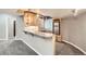 Basement bar area with wooden cabinets, granite countertop, sink, and small refrigerator at 1007 Thorncreek Ct, Thornton, CO 80241