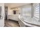 Bright bathroom boasts a soaking tub beneath a window and dual sinks with a large mirror at 1007 Thorncreek Ct, Thornton, CO 80241