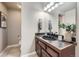 Stylish half bath features a dark vanity with a vessel sink and granite countertops at 1007 Thorncreek Ct, Thornton, CO 80241