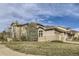 Expansive home shows manicured lawn, neutral paint, stone accents, and three car garage at 1007 Thorncreek Ct, Thornton, CO 80241