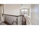 Well-lit staircase with dark wood railing and chandelier features a large window with neighborhood views at 1007 Thorncreek Ct, Thornton, CO 80241