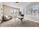Bright home office with large windows, white desk, comfortable chair, and built in bookshelf at 1007 Thorncreek Ct, Thornton, CO 80241
