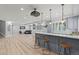 Open basement bar with seating, stylish pendant lights, and gray cabinetry at 9468 E Aspen Hill Ln, Lone Tree, CO 80124