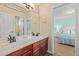 Bathroom featuring dual sinks and vanity with a view to a light and airy bedroom with a bright color palette at 9468 E Aspen Hill Ln, Lone Tree, CO 80124