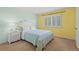 Bright bedroom with yellow accent wall, white shutters, and patterned blue bedding at 9468 E Aspen Hill Ln, Lone Tree, CO 80124