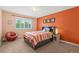 Charming bedroom with vibrant orange walls, a cozy bed, and a unique basketball chair for a playful touch at 9468 E Aspen Hill Ln, Lone Tree, CO 80124
