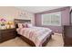 Cozy bedroom featuring purple tones, shuttered windows, and stylish furnishings at 9468 E Aspen Hill Ln, Lone Tree, CO 80124