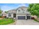 Charming two-story home featuring a well-manicured lawn and a three car garage at 9468 E Aspen Hill Ln, Lone Tree, CO 80124