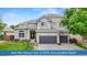 Stunning two-story home featuring a well-manicured lawn, elegant architecture, and a three-car garage at 9468 E Aspen Hill Ln, Lone Tree, CO 80124