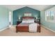 This main bedroom features a large, dark wood bed frame, complemented by soft, neutral walls and elegant bedside tables at 9468 E Aspen Hill Ln, Lone Tree, CO 80124