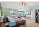 The main bedroom features calming color palette, plush carpets, ceiling fan, a large TV, and an adjacent sitting area at 9468 E Aspen Hill Ln, Lone Tree, CO 80124