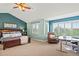 Spacious main bedroom boasts a ceiling fan, large windows, and a comfortable sitting area, perfect for relaxation and work at 9468 E Aspen Hill Ln, Lone Tree, CO 80124