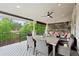 Large covered patio with outdoor dining, ceiling fan, exterior shades, and views of the surrounding trees at 9468 E Aspen Hill Ln, Lone Tree, CO 80124