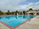 Community swimming pool with clear blue water, lounge chairs, and a lifeguard stand at 9468 E Aspen Hill Ln, Lone Tree, CO 80124
