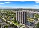 An aerial view of a high-rise condominium building surrounded by lush landscaping and a beautiful city skyline at 3131 E Alameda Ave # 803, Denver, CO 80209