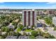 An aerial shot of a high-rise condominium building surrounded by neighborhood, lush landscaping, and city skyline at 3131 E Alameda Ave # 803, Denver, CO 80209