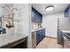 A modern kitchenette features navy cabinets, stainless steel appliances, and granite countertops at 3131 E Alameda Ave # 803, Denver, CO 80209