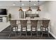 Basement bar area featuring stylish pendant lighting, white cabinetry, stainless steel appliances, and modern barstools at 6766 Mentha Dr, Castle Rock, CO 80108