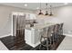 Modern bar area featuring a stainless steel refrigerator, wine cooler, quartz countertops, and stylish pendant lights at 6766 Mentha Dr, Castle Rock, CO 80108