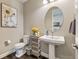 Cozy bathroom features a pedestal sink, oval mirror, and woven basket storage shelves at 6766 Mentha Dr, Castle Rock, CO 80108