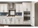 Well-equipped kitchen featuring stainless steel appliances, white cabinetry, and a modern backsplash at 6766 Mentha Dr, Castle Rock, CO 80108