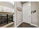 A clean laundry room with new front-load washer and dryer, storage cabinets, and a door at 6766 Mentha Dr, Castle Rock, CO 80108