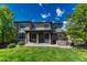 Expansive backyard featuring a covered patio, pergola, lush lawn, and attractive landscaping at 15235 W Iliff Ave, Lakewood, CO 80228