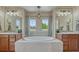 Elegant bathroom features a soaking tub, dual sinks, and contemporary lighting at 15235 W Iliff Ave, Lakewood, CO 80228