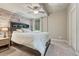 Cozy bedroom features stylish accent wall, modern ceiling fan, and natural light at 15235 W Iliff Ave, Lakewood, CO 80228