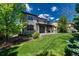 Charming two-story home with lush lawn, covered patio, mature trees, and attractive landscaping at 15235 W Iliff Ave, Lakewood, CO 80228