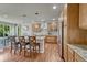 Open kitchen boasts wood cabinets, granite countertops, stainless appliances, pendant lights, and bar seating at 15235 W Iliff Ave, Lakewood, CO 80228