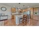Spacious kitchen featuring an island with bar seating, stainless steel appliances, and hardwood floors at 15235 W Iliff Ave, Lakewood, CO 80228