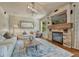 Inviting living room features a stone fireplace, rustic wood mantel, comfortable seating and stylish decor at 15235 W Iliff Ave, Lakewood, CO 80228
