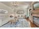 Cozy living room showcases a stone fireplace, rustic mantel, comfortable seating, and chic decor at 15235 W Iliff Ave, Lakewood, CO 80228