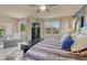 Bright main bedroom showcasing large windows, ceiling fan, and comfortable decor at 15235 W Iliff Ave, Lakewood, CO 80228